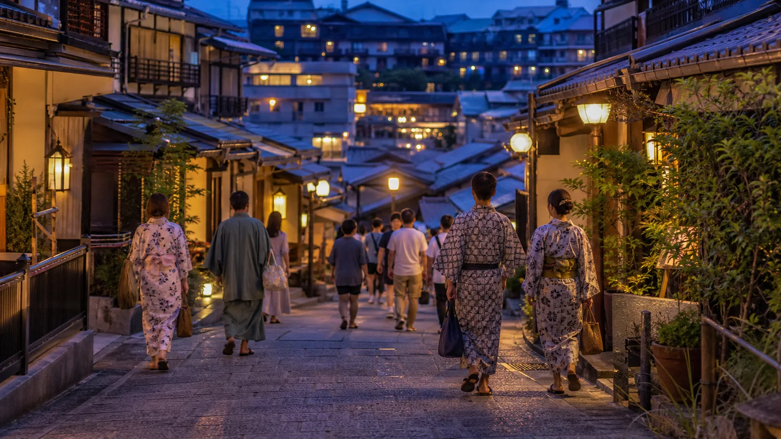 夕暮れの温泉街を浴衣で歩く道後の旅行者