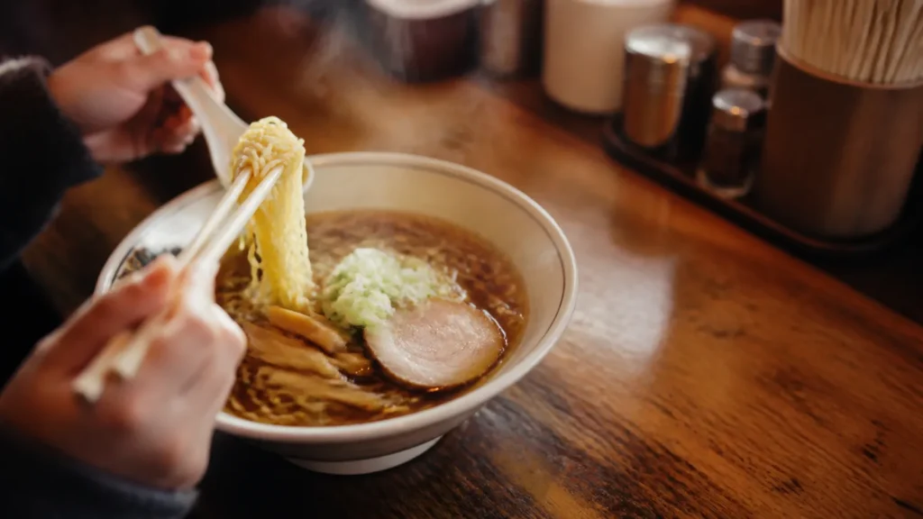 旭川の老舗食堂を思わせるカウンターに置かれた醤油ラーメンの編集イメージ