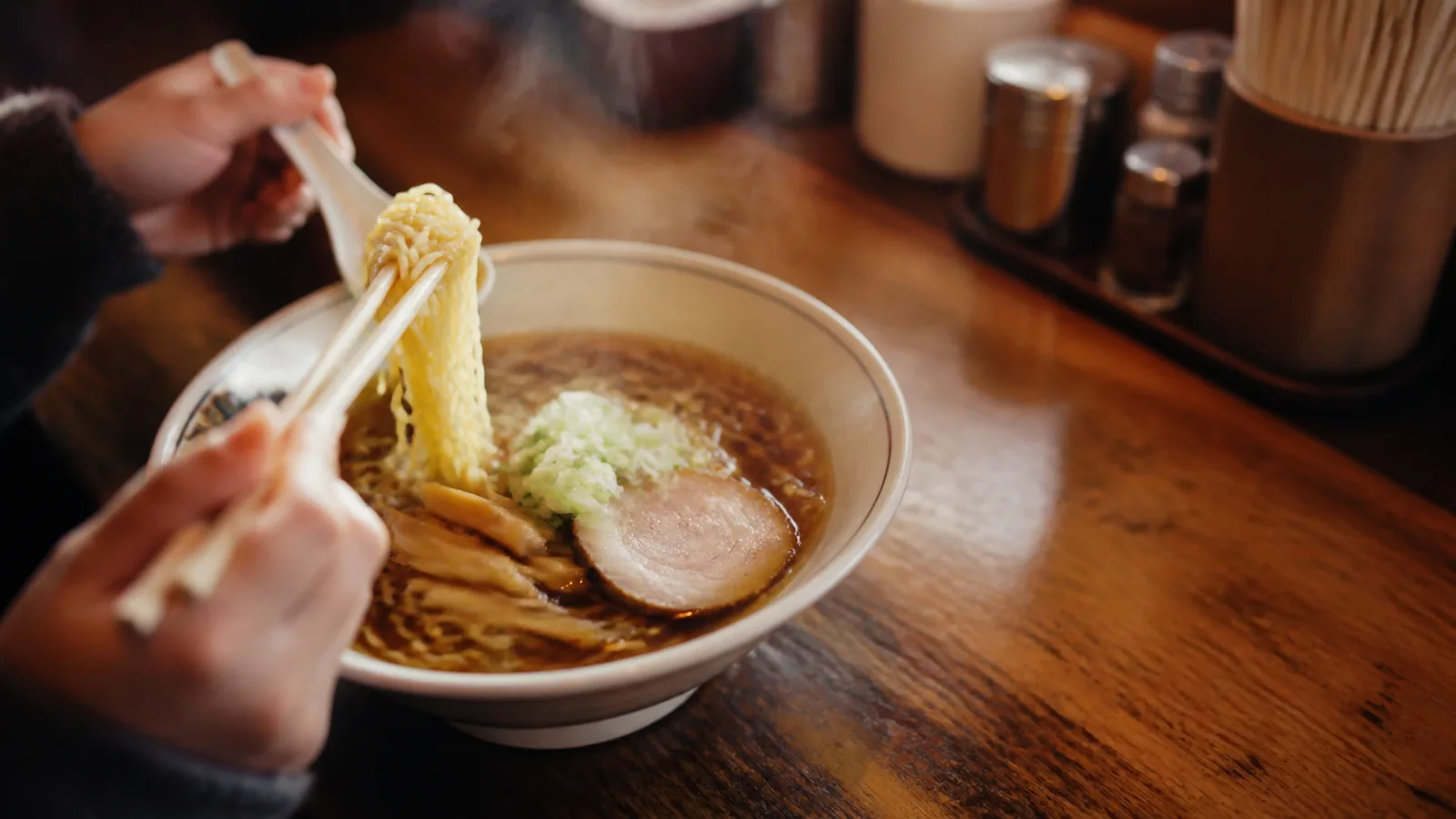 旭川の老舗食堂を思わせるカウンターに置かれた醤油ラーメンの編集イメージ