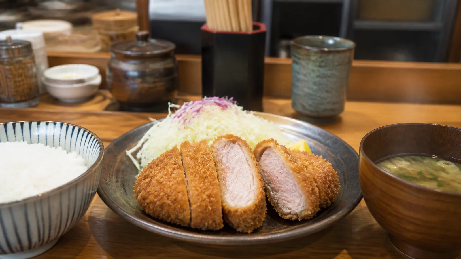 鹿児島の食堂で厚切りの黒豚とんかつ定食を味わう場面の編集イメージ
