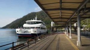 宮島の桟橋に停泊する無地のフェリーと屋根付き通路の編集イメージ