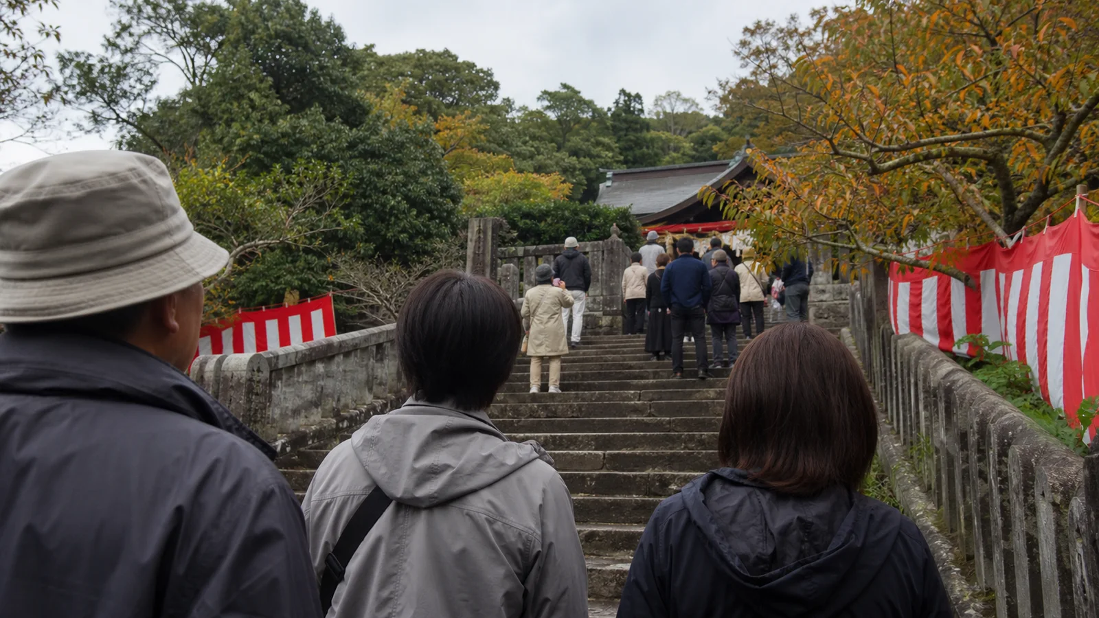 長崎の神社へ続く石段で秋祭りを待つ旅行者