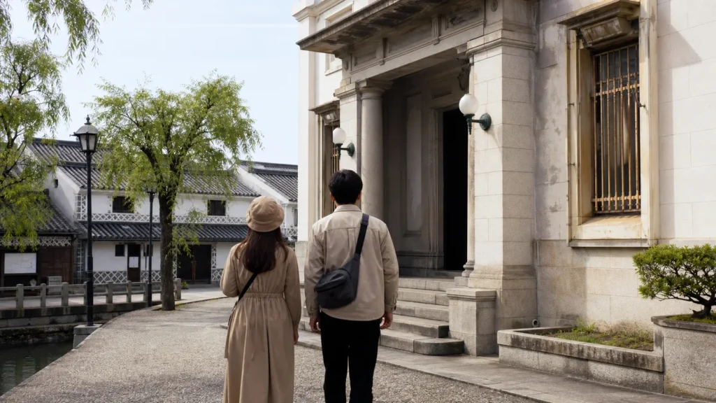 白壁と石造りの美術館入口へ向かう倉敷の旅行者