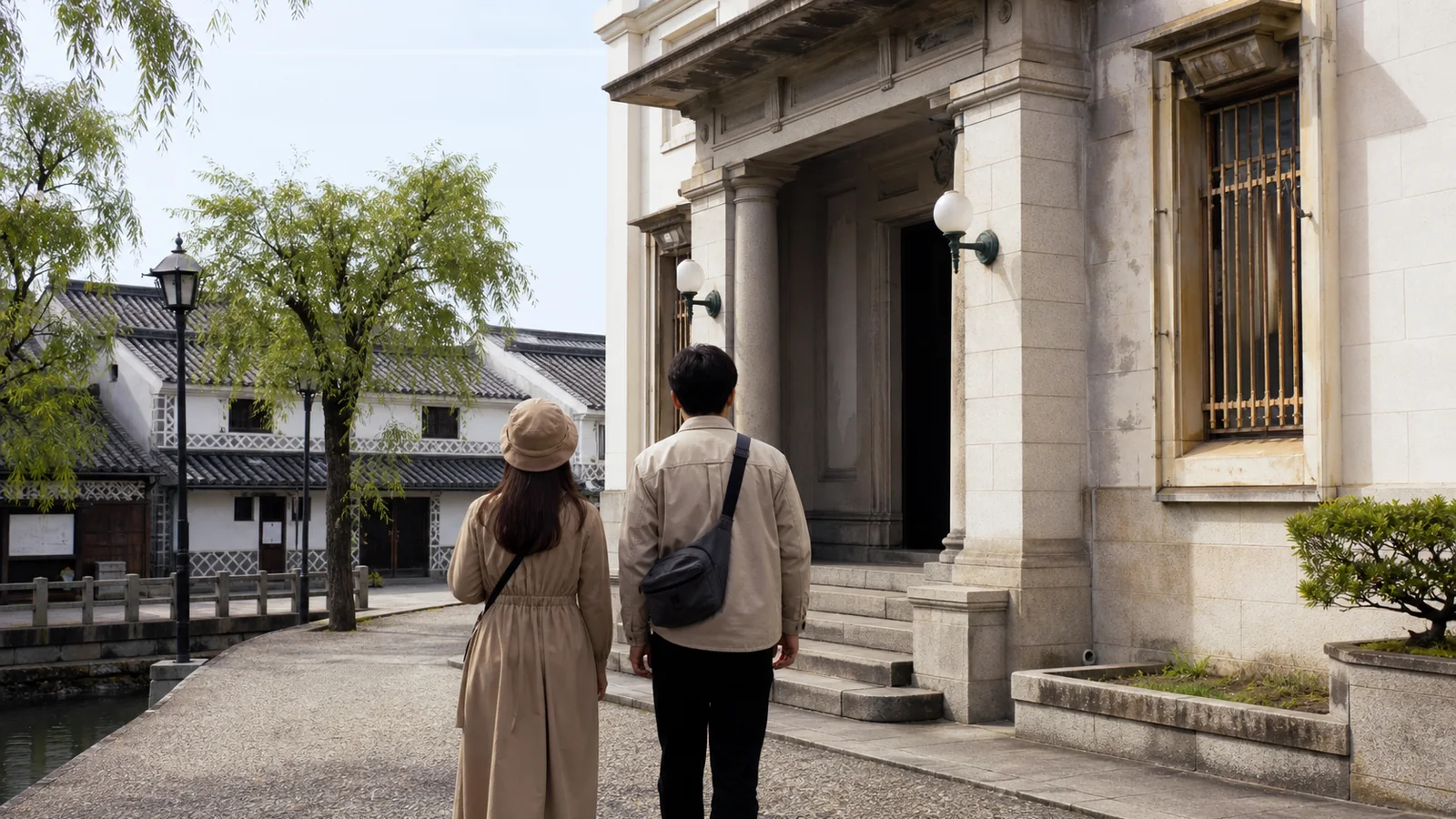 白壁と石造りの美術館入口へ向かう倉敷の旅行者