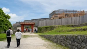 復元工事が進む沖縄の城跡公園を歩く旅行者
