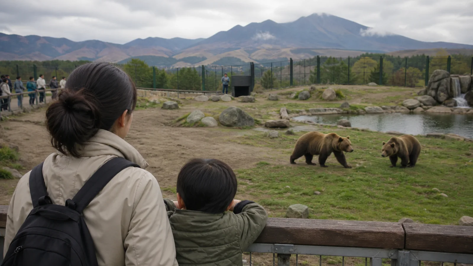 阿蘇を思わせる山並みの前でクマを観察する親子