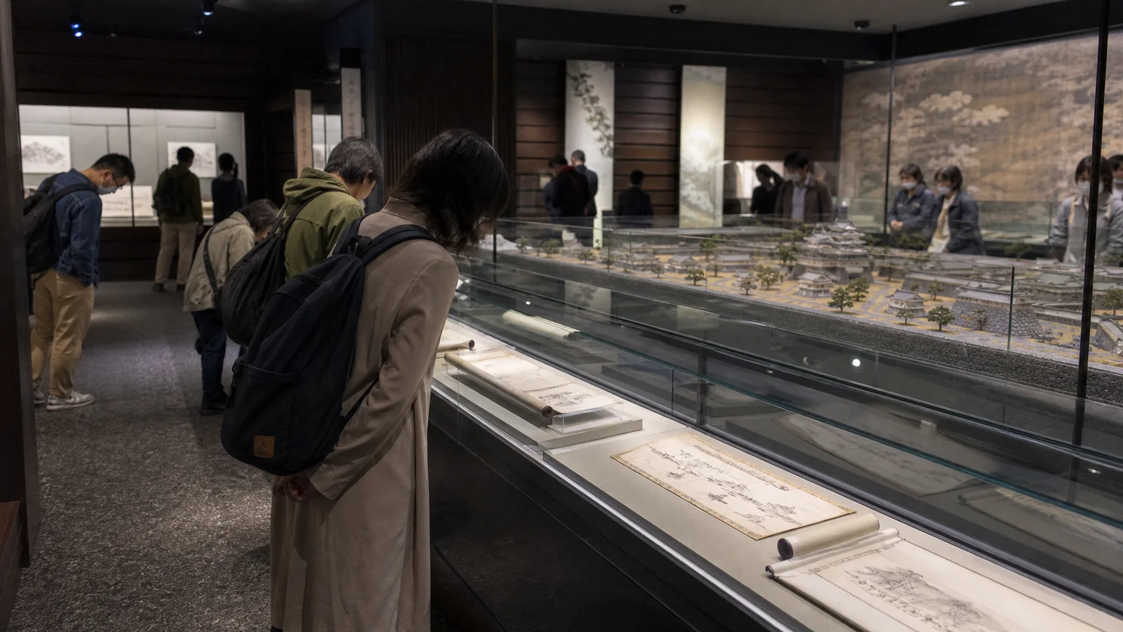 城下町模型と古文書の展示を見る旅行者