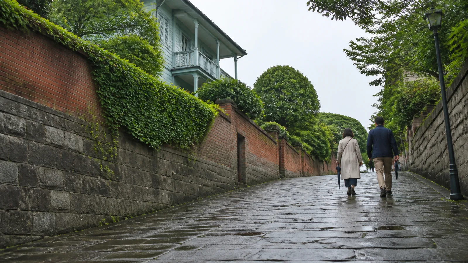 雨上がりの石畳の坂を歩く旅行者の編集イメージ