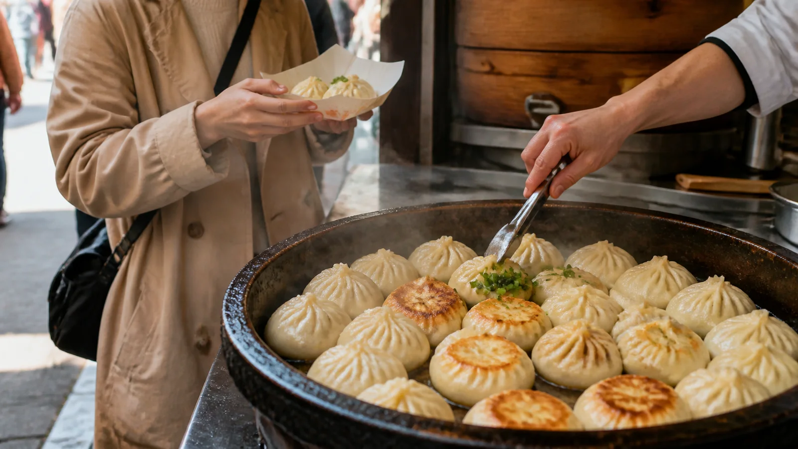 大きな鉄鍋で焼かれた小籠包を紙トレーで受け取る旅行者