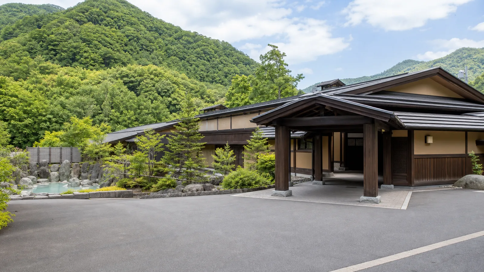定山渓の山を背にした日帰り温泉施設の無人外観の編集イメージ