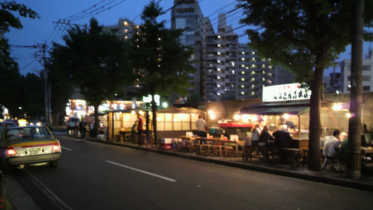 夕暮れの道路沿いに屋台が並ぶ福岡市の長浜屋台街
