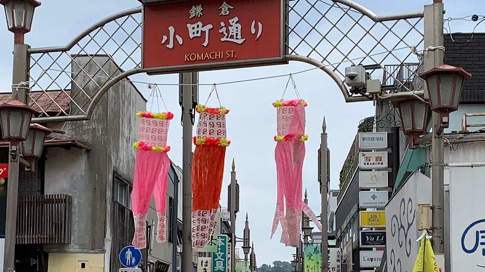 鎌倉小町通りの入口を示すアーチと通りの店並み