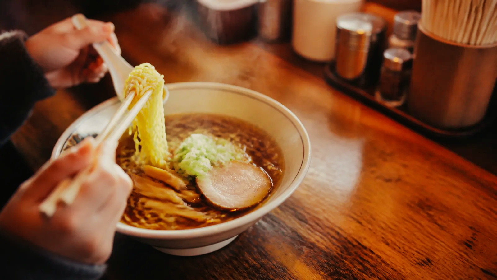旭川の老舗食堂を思わせるカウンターに置かれた醤油ラーメンの編集イメージ