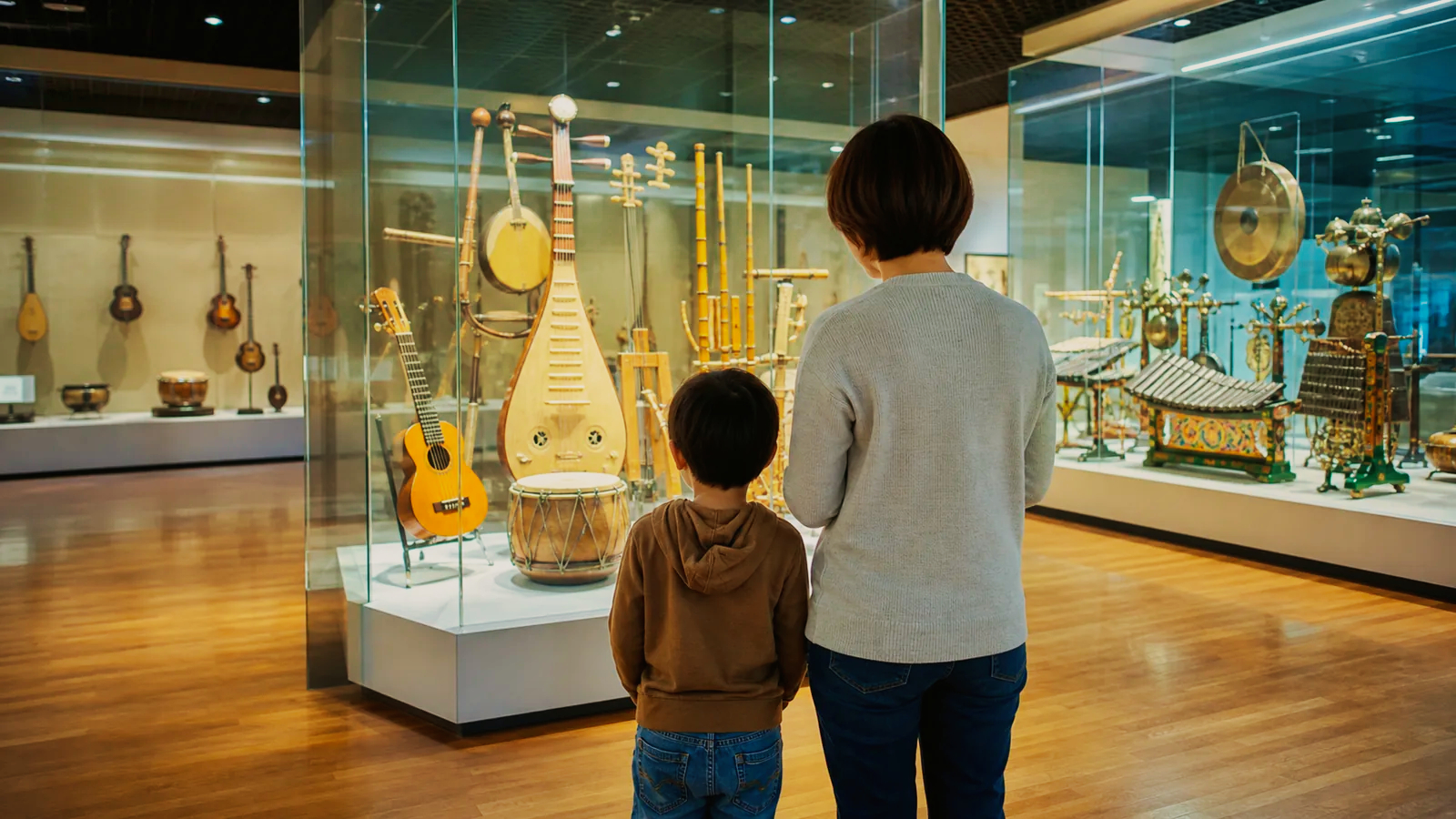 世界の楽器が並ぶ展示室を親子で見学する様子を表した編集イメージ