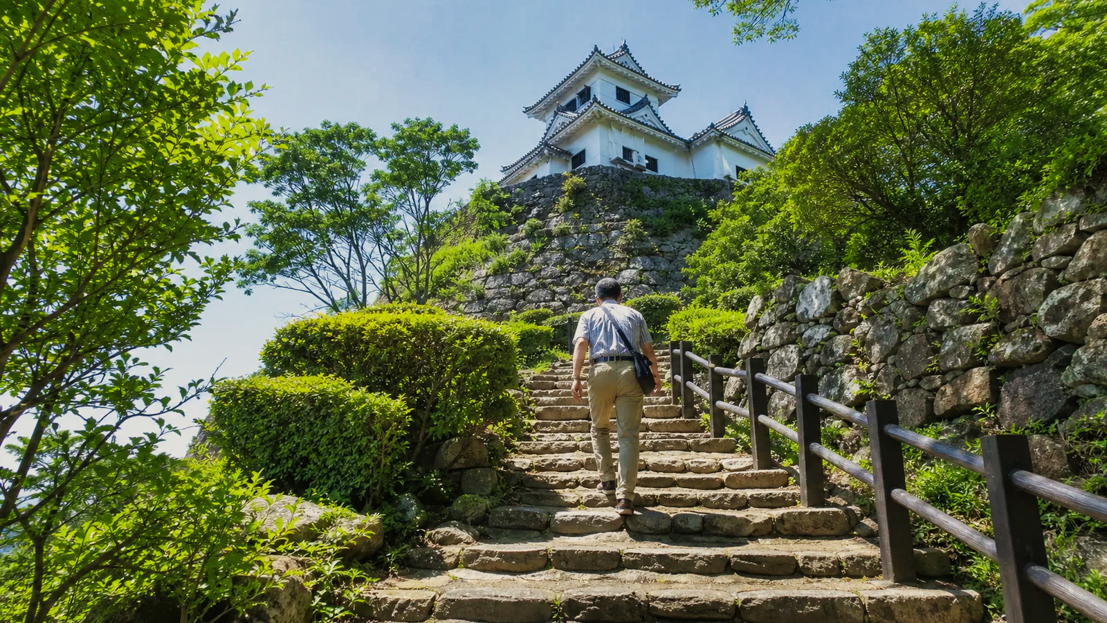 四国の城を思わせる天守と石段を訪ねる旅行者