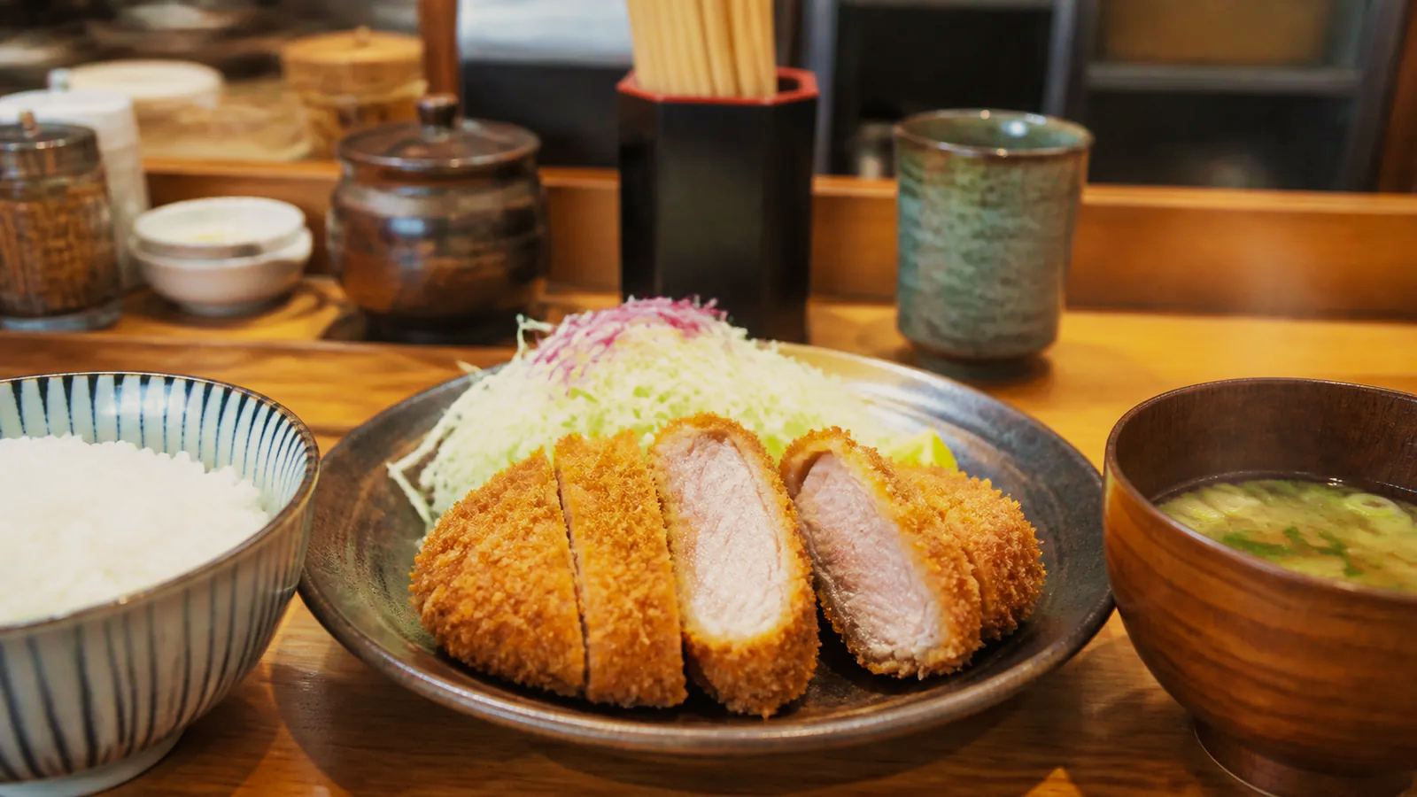 鹿児島の食堂で厚切りの黒豚とんかつ定食を味わう場面の編集イメージ