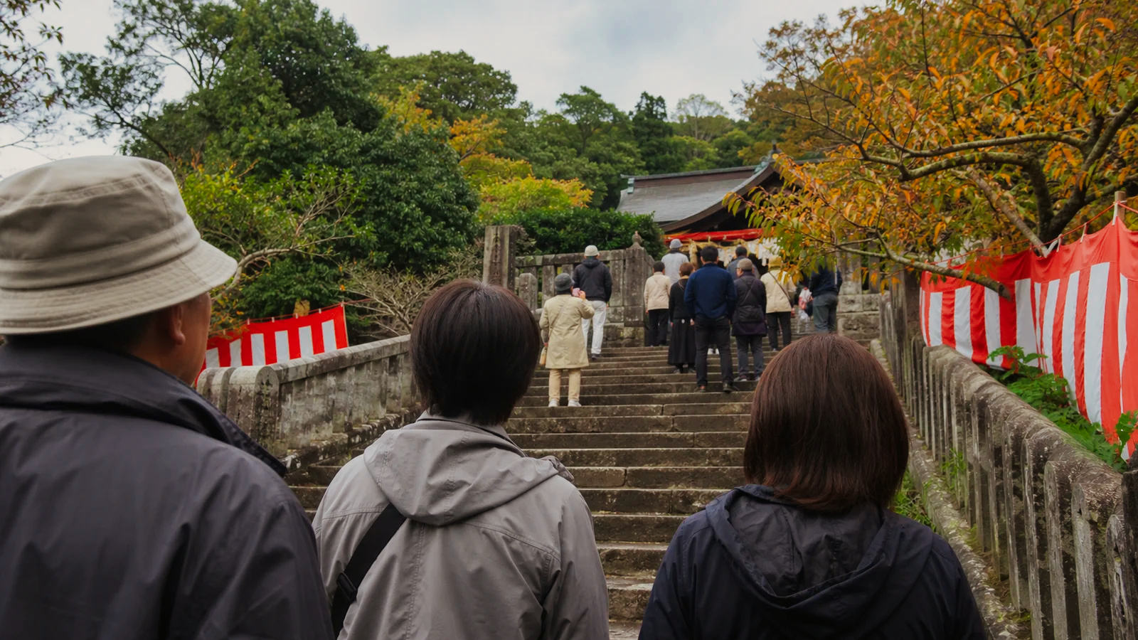 長崎の神社へ続く石段で秋祭りを待つ旅行者