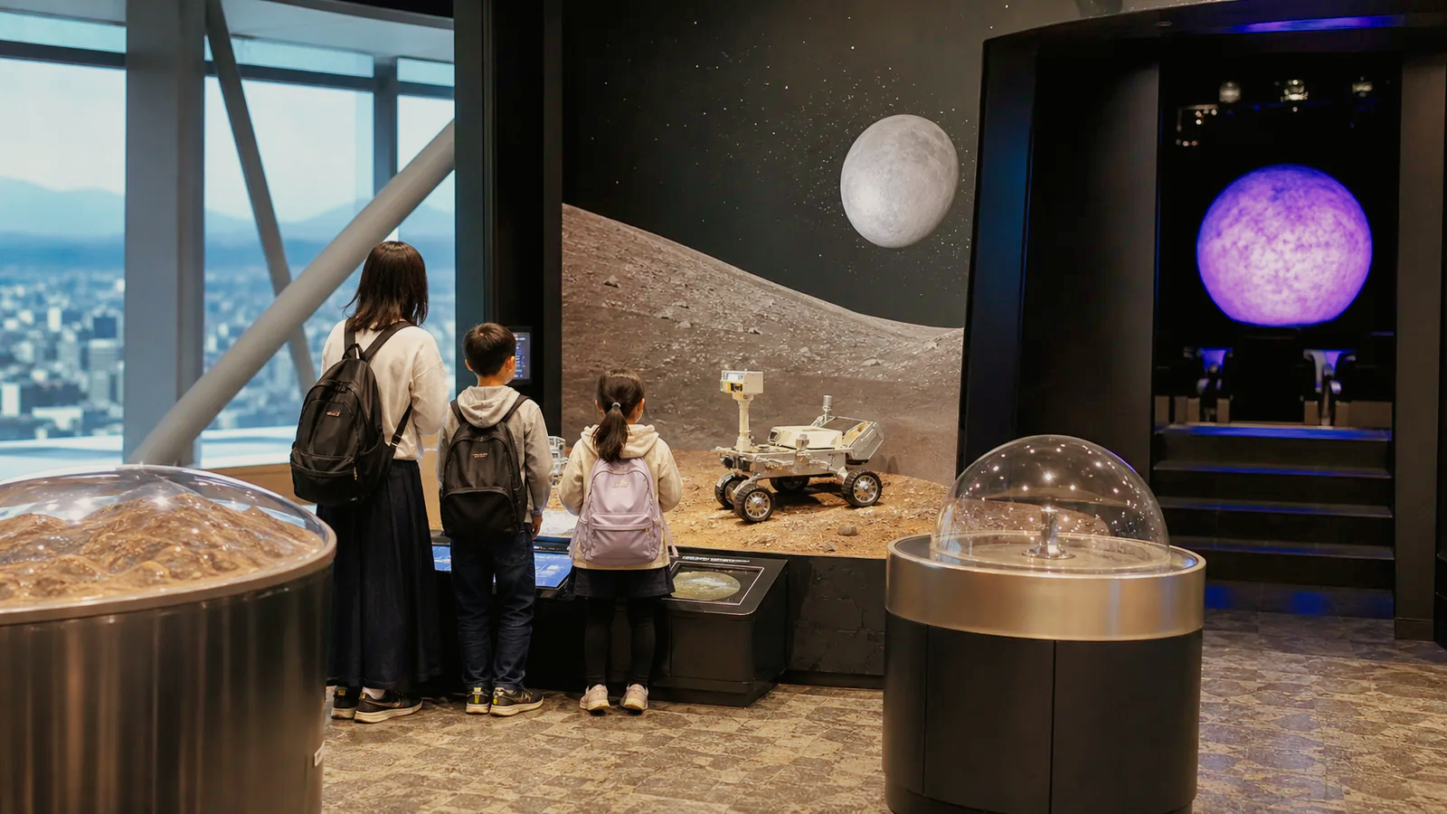 郡山の高層階にある科学館で親子が宇宙展示を見る編集イメージ