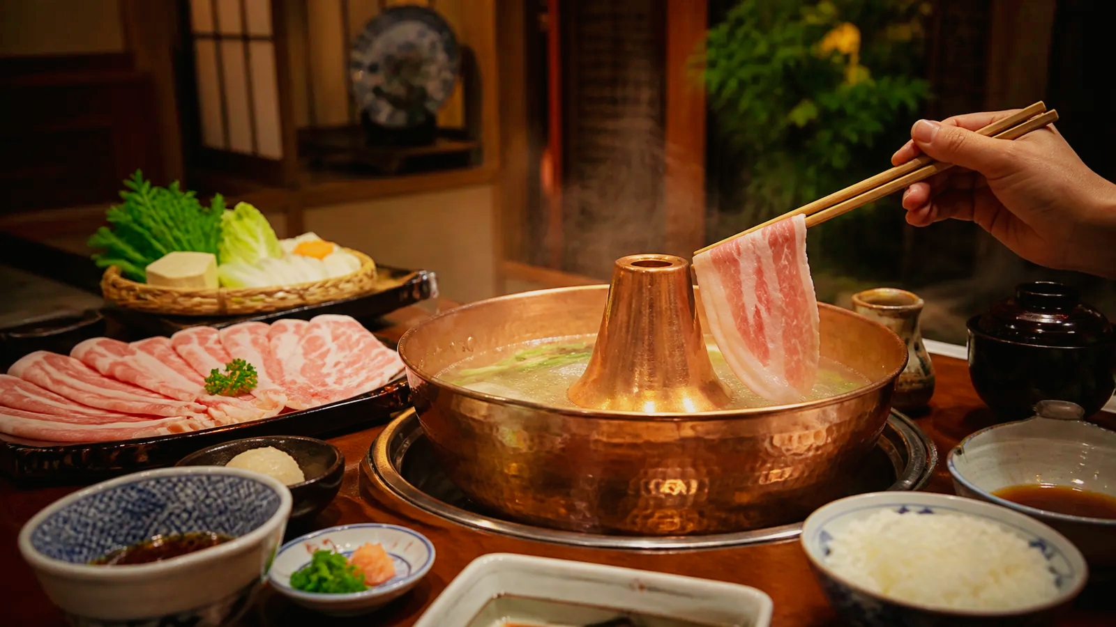 天文館の落ち着いた店で黒豚しゃぶしゃぶを鍋にくぐらせる場面の編集イメージ
