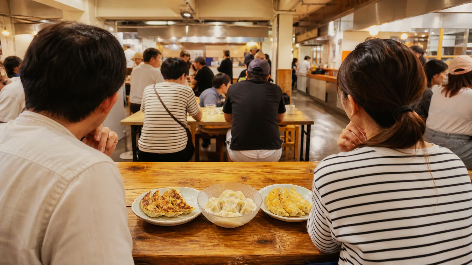 宇都宮のフードホールで焼き餃子や水餃子を食べ比べる旅行者