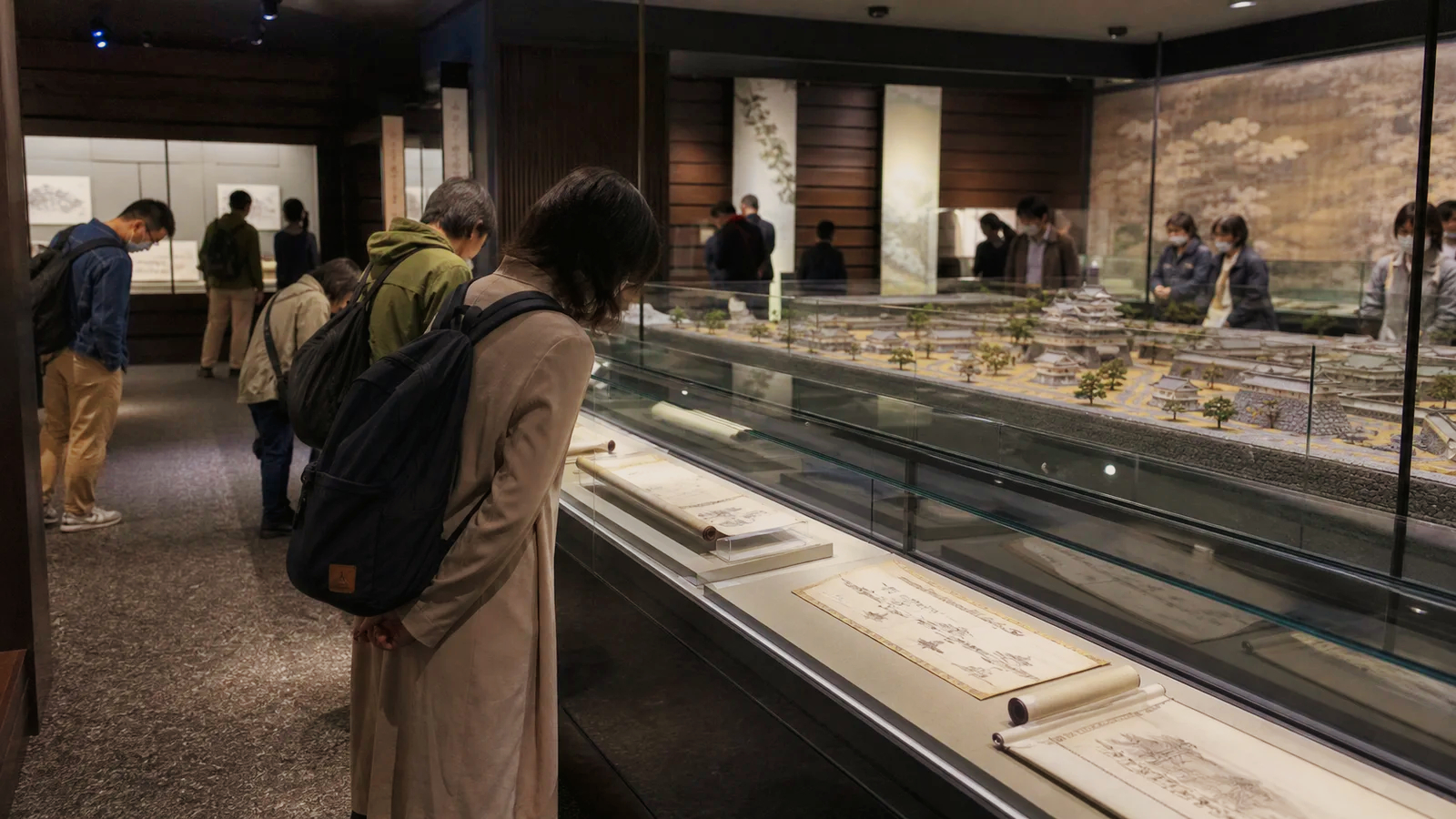 城下町模型と古文書の展示を見る旅行者