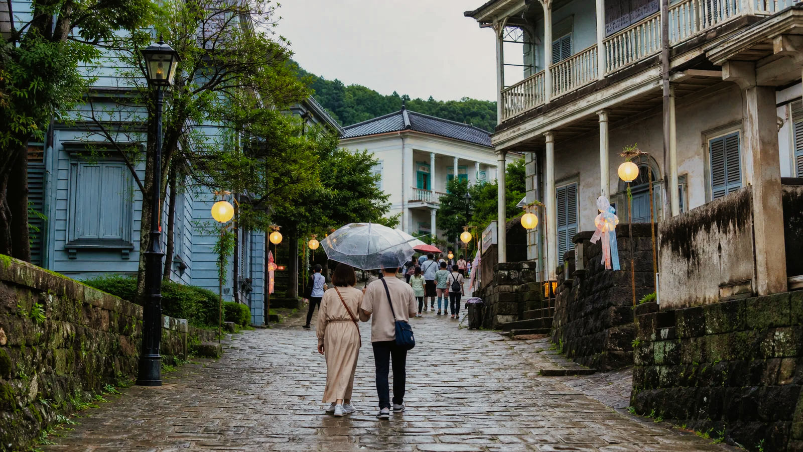 長崎の洋館が並ぶ坂道を秋に歩く旅行者