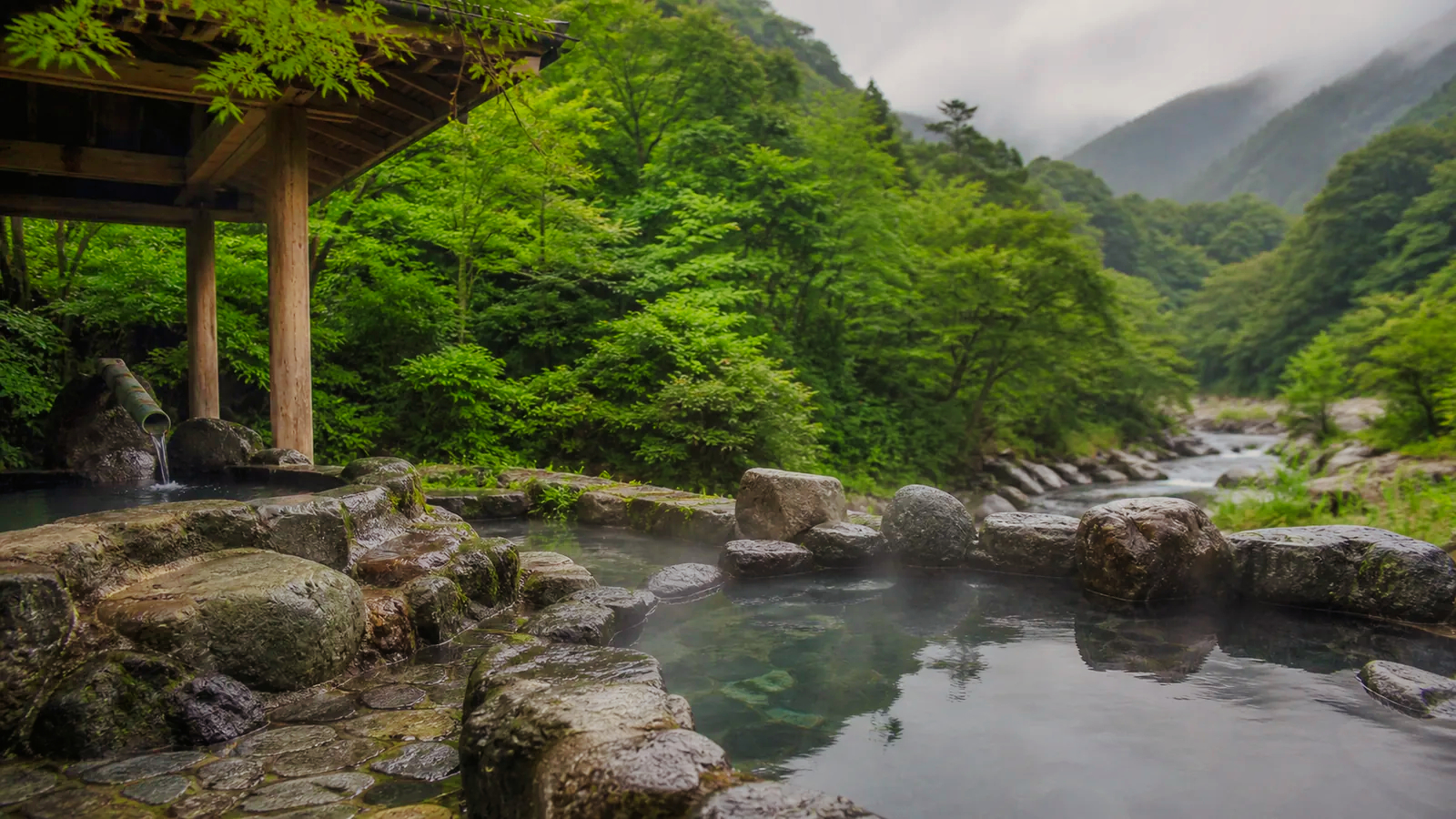 箱根の山と渓流を望む空の露天風呂の編集イメージ