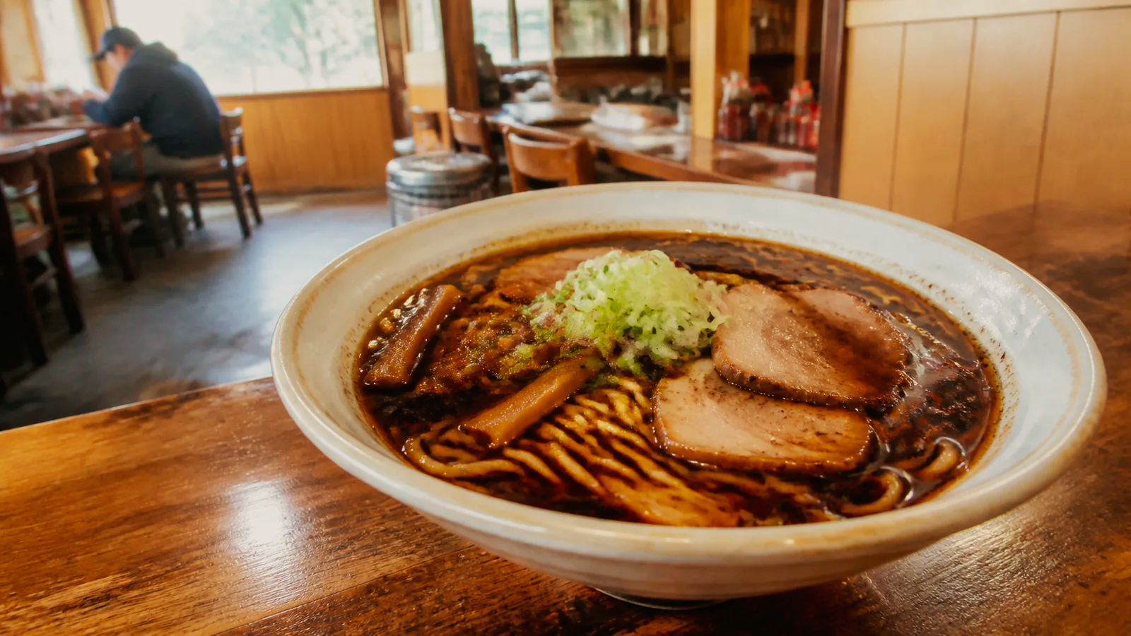 香ばしい醤油スープのラーメンを小さな食堂で味わう場面の編集イメージ