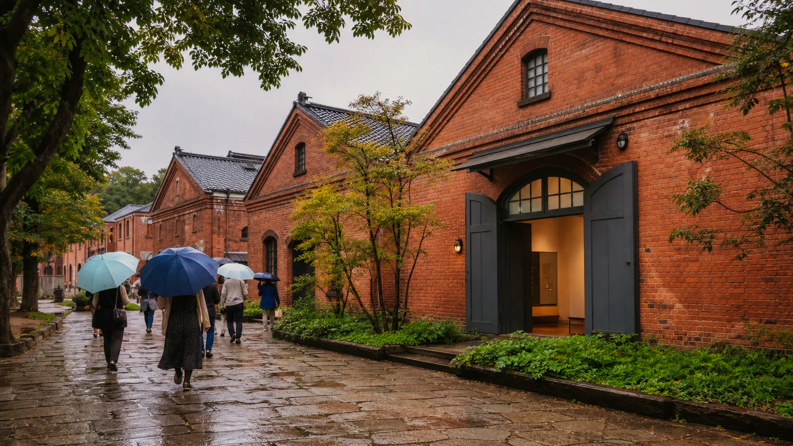 雨の赤れんが建築へ傘を差して向かう旅行者
