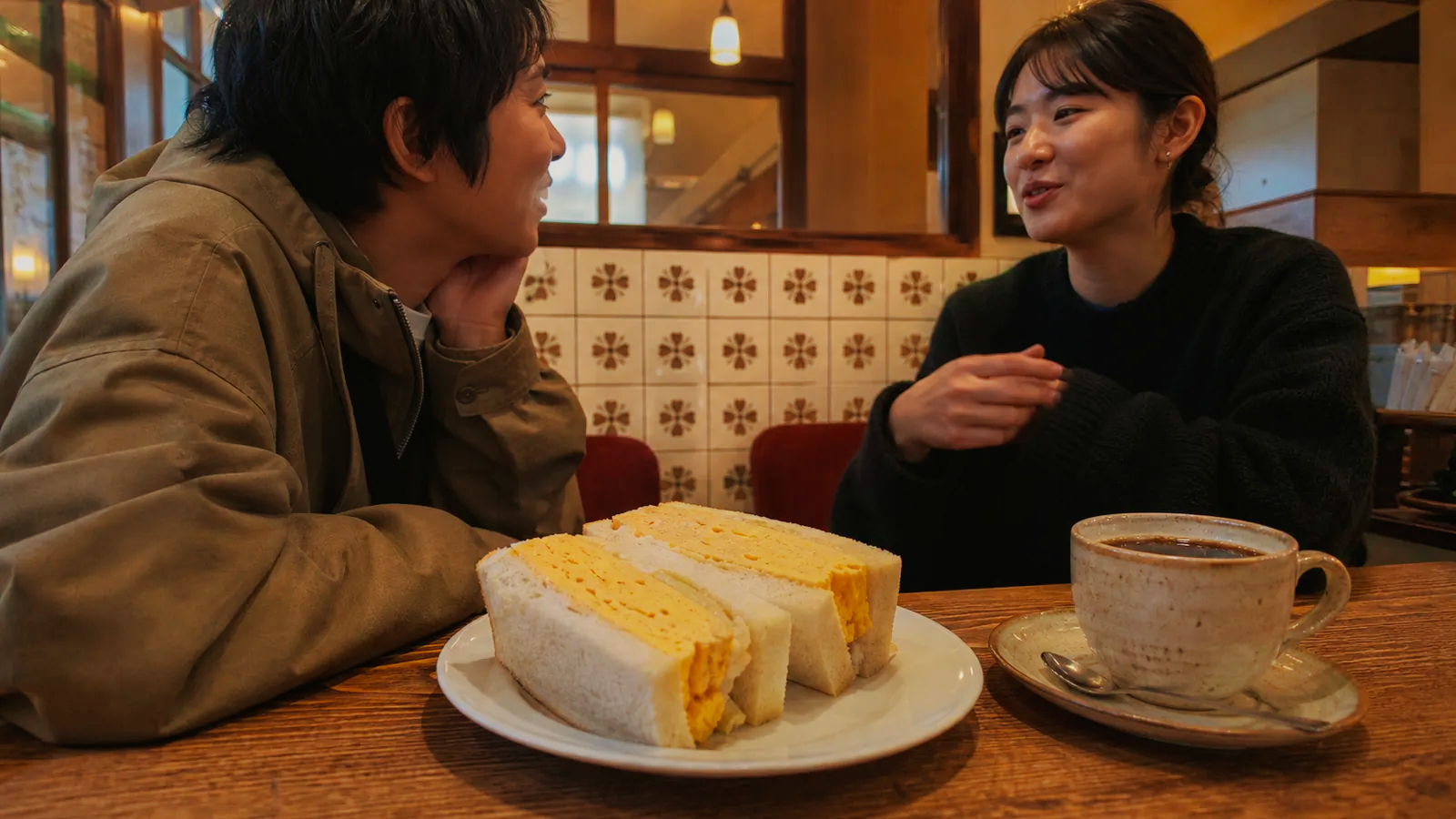 厚みのあるタマゴサンドとコーヒーを囲む朝のテーブル