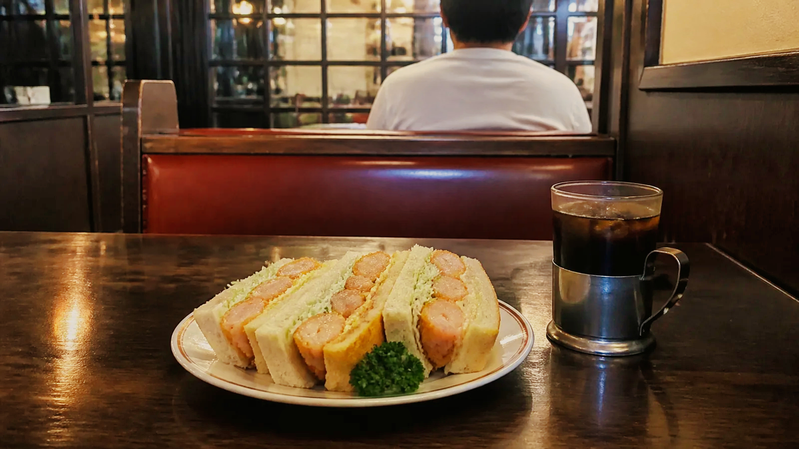 揚げた海老とキャベツを挟んだ厚いサンドイッチとアイスコーヒー