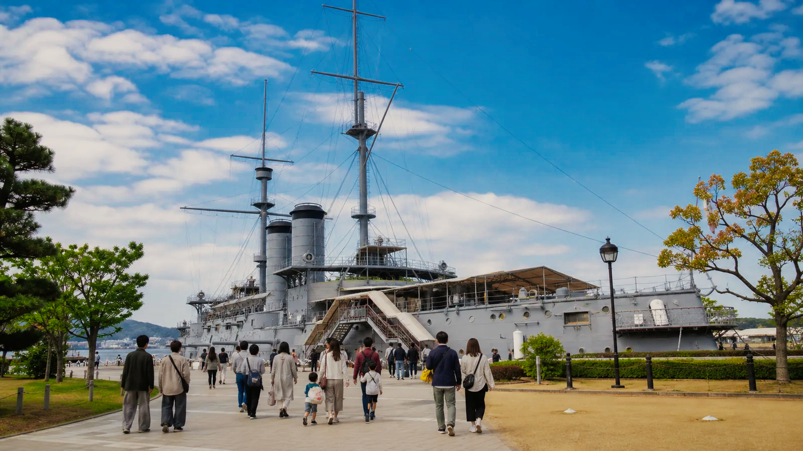 海辺の公園に保存された歴史的な記念艦へ向かう編集イメージ