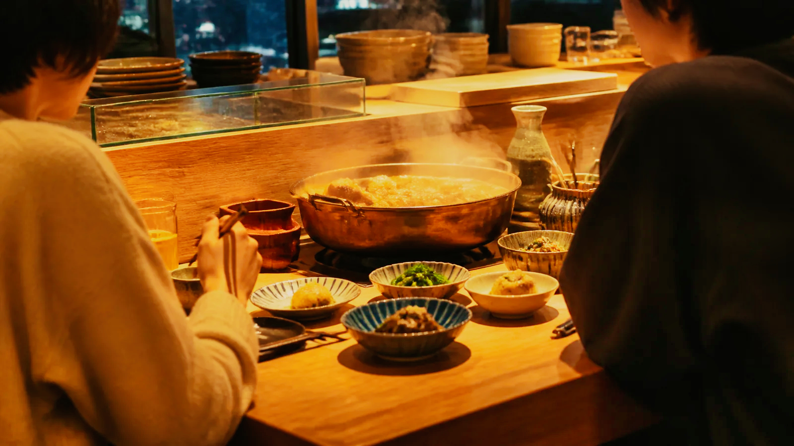 片町の現代的な酒場でおでんと小鉢を囲む二人の編集イメージ