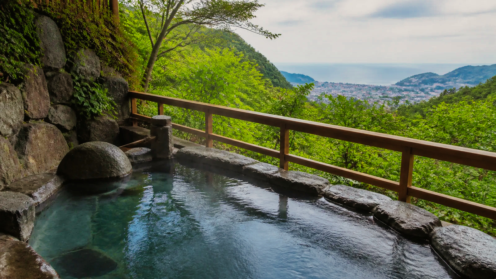 伊東の山あいから海を望む無人の貸切露天風呂を表した編集イメージ