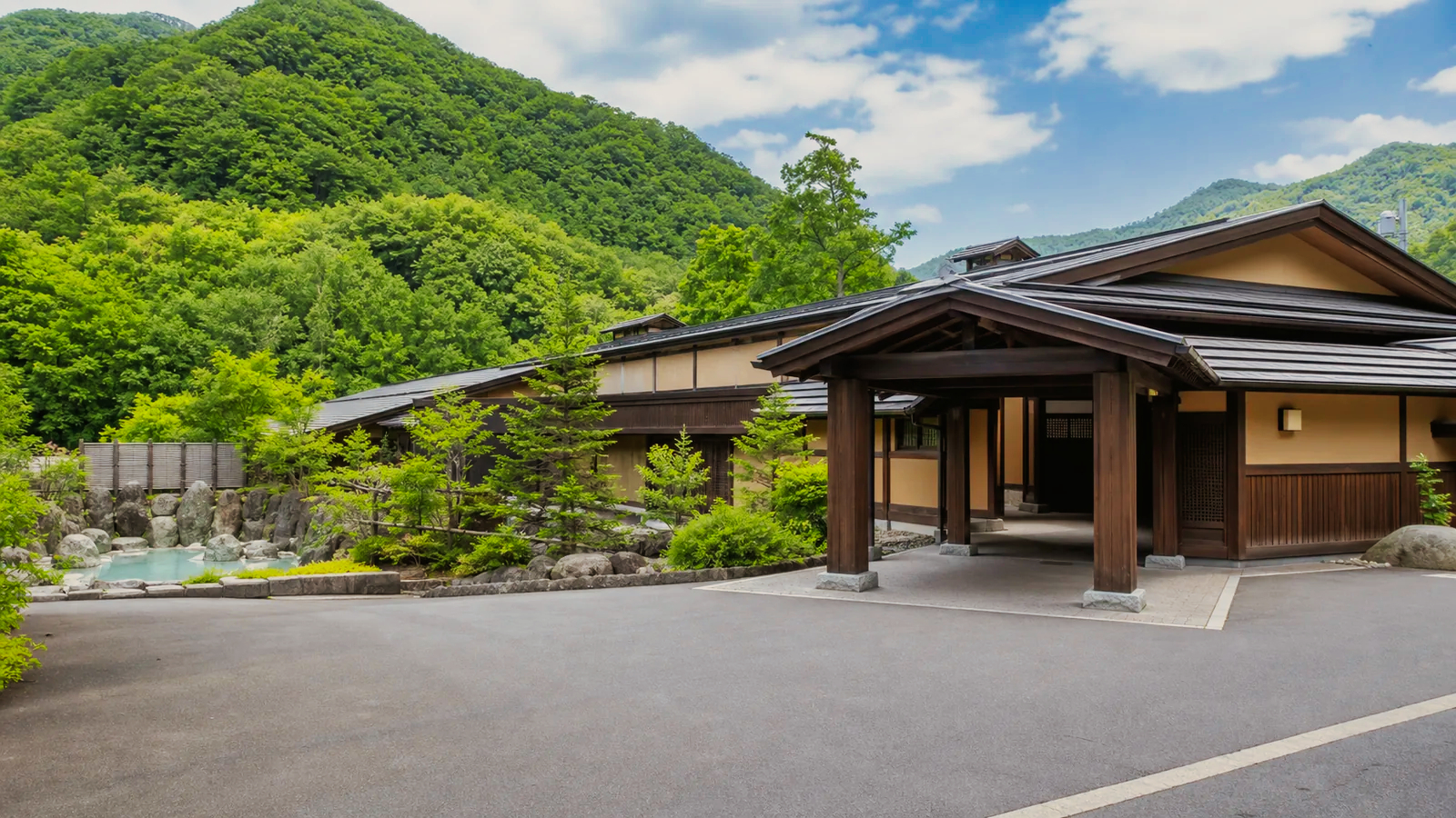 定山渓の山を背にした日帰り温泉施設の無人外観の編集イメージ