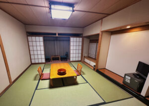 畳敷きの旅館客室に座卓と座椅子を備えた和室の一例