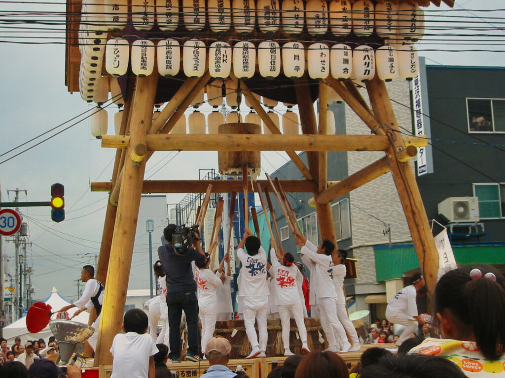 岩見沢ふるさと百餅祭りの巨大な杵を引き上げる参加者（2007年撮影）